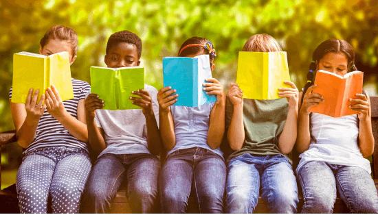 Five children sit on a bench, reading books.